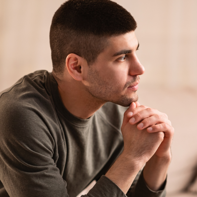 man sitting down pondering